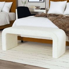 a white bed sitting next to a wooden headboard and foot board on top of a hard wood floor