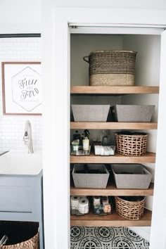 a bathroom closet with baskets on the shelves and toiletries in the bins next to it