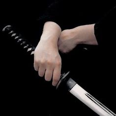 a person holding a knife in their hand with both hands on the handle and one arm