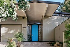 a blue door sits in front of a house with steps leading up to the entrance