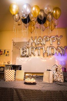 a birthday party with balloons and presents on the table