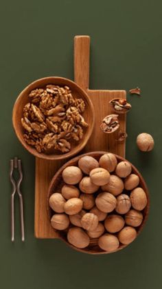 nuts in wooden bowls and spoons on a cutting board