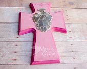 a pink wooden cross with an angel on it