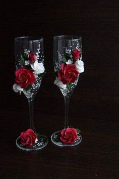 two wine glasses with red and white flowers on them