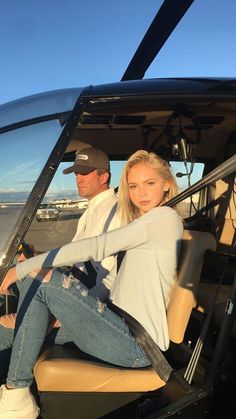 a man and woman sitting in the cockpit of a helicopter