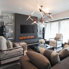 a living room filled with furniture and a flat screen tv mounted to the wall next to a fire place