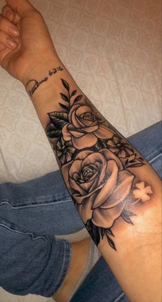 a woman's arm with flowers on it and the word love written in black ink