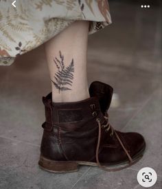 a close up of a person's foot with a fern tattoo on their ankle