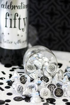 a bottle of wine sitting next to some candies on top of a tablecloth