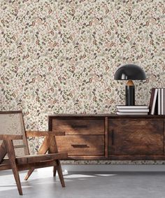 a chair and table in front of a wallpapered room with flowers on it