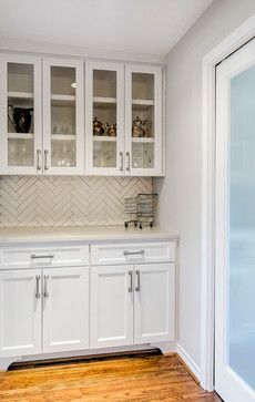 a kitchen with white cabinets and wood floors