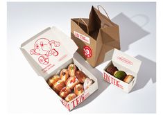 an open box of donuts next to two boxes of doughnuts