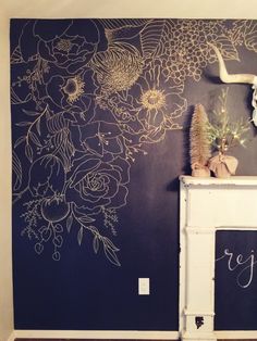 there is a fireplace with flowers painted on the wall and a chalkboard in front of it