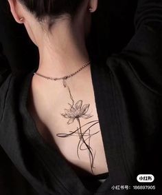 a woman with a flower tattoo on her chest is looking down at the viewer's shoulder