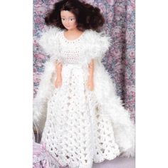 a crocheted doll is wearing a white dress