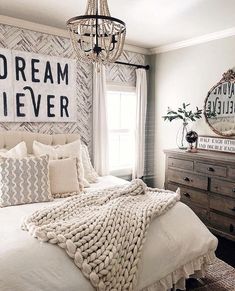 a bedroom with a bed, dresser and chandelier