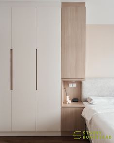 a white bed sitting next to a wooden cabinet in a room with hardwood flooring