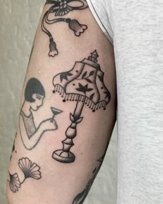 a man's arm with tattoos on it, including a lamp and other items