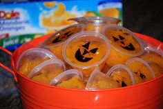 oranges in plastic containers with jack o lantern faces on them