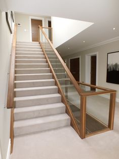 a staircase with glass balustrade and wooden handrails in a house setting