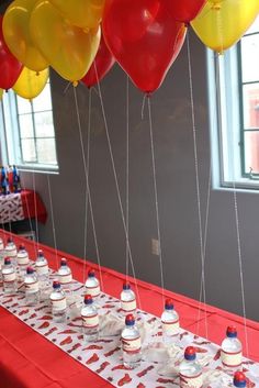 balloons are attached to the table with water bottles on it and red, white, and blue streamers