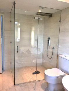 a bathroom with a walk in shower next to a white toilet and a bidet