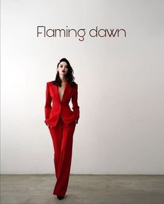 a woman in a red suit and heels standing next to a white wall with the words flaminging dawn on it