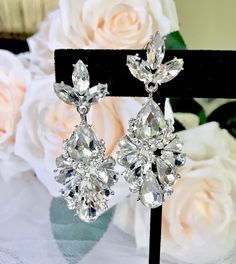 A delightfully unique pair of bridal earrings with an incredible sparkle! Lightweight, the earrings are adorned with flawlessly faceted rhinestone crystals that capture the light in a dazzling array of sparkles, and are rhodium/gold plated for a bright finish which enhances the intricate detailing and conveys a modern take on old elegance. Length: 2" (approx. 5cm). Available in Silver and Yellow Gold finishes. To make your choice select your preferred finish from the dropdown menu. Hypoallergeni Glamorous Diamond Earrings With Sparkling Stones For Wedding, Diamond White Cubic Zirconia Bridal Earrings For Party, Glamorous Diamond Earrings With Sparkling Stones, Glamorous Cubic Zirconia Diamond Earrings With Sparkling Stones, Diamond White Cubic Zirconia Chandelier Earrings For Party, Glamorous Sparkling Diamond Earrings For Wedding, Glamorous Sparkling Diamond Wedding Earrings, Dazzling Diamond Earrings For Wedding, Glamorous Diamond Drop Bridal Earrings