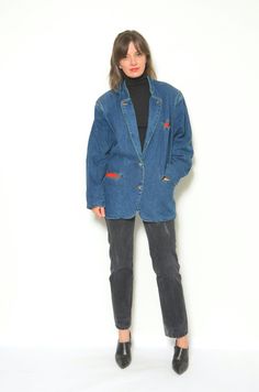 This is a vintage 80s folk denim jacket with a jean button and an Austrian style blazer. It is made of 100% cotton denim and has a quality and durable feel. The jacket has a front button closure, two chest pockets with button flaps, and two side pockets. The jacket features a folk style, with a warm lining in a red and black plaid pattern. The lining is made of 100% wool and has a cozy and soft feel. The jacket also has a collar, long sleeves, and a fitted shape that accentuates the figure. The Winter Denim Blazer With Buttons, Medium Wash Cotton Blazer With Button Closure, Winter Denim Blue Denim Blazer, Retro Cotton Blazer With Button Closure, Retro Denim Jacket For Spring Workwear, Vintage Single Breasted Denim Jacket For Fall, Vintage Cotton Blazer With Button Closure, Retro Cotton Denim Jacket For Workwear, Vintage Single Breasted Cotton Denim Jacket