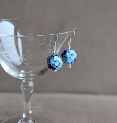 These Dark and Light Blue Raised Floral Lampwork Glass Bead with Crystal earrings are great for every day or an evening out!   An excellent Mother's Day Gift, Birthday Gift, Holiday or anytime earring!   The earrings have a 1 1/2" drop, and Sterling Silver ear wires.  The floral glass bead is approximately 1/2" (15mm)  in diameter.  The raised blue glass flowers (with a tiny pink or blue center and green leafs) are on a lampwork glass bead with a black core. The blue crystals are 2 mm.   The earring comes with sterling silver earwires. However, If you need Niobium ear wires for allergy purposes, please send a message to me with your order/payment. Niobium wire offers outstanding qualities, including being non-reactive with those who have sensitive skin or metal allergies.  The niobium earw Blue Wire Wrapped Beaded Earrings For Party, Blue Wire-wrapped Glass Earrings, Blue Wire Wrapped Glass Earrings, Blue Glass Wire Wrapped Earrings, Blue Wire Wrapped Beaded Earrings, Blue Wire Wrapped Round Beaded Earrings, Blue Round Wire Wrapped Beaded Earrings, Blue Czech Glass Earrings For Party, Blue Czech Glass Wire Wrapped Beaded Earrings