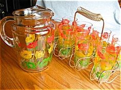 many glasses are lined up on a table with a teapot and other glassware