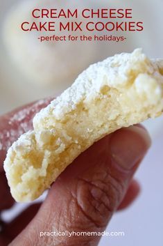 a hand holding a half eaten cream cheese cake mix cookies