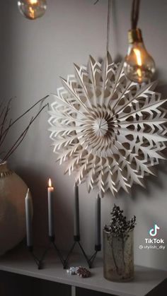 some candles are sitting on a shelf next to an ornament