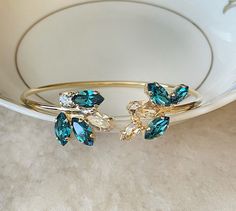 Pretty open bangle bracelet featuring 8x4mm and 10x5mm Swarovski crystals in shades of champagne and teal. Bracelet is adjustable, opens from the top. Thanks for stopping by! Blue Cuff Bracelet For Wedding, Lady Aesthetic, Champagne Jewelry, Teal Jewelry, Teal Bracelet, Open Bangle Bracelet, Bracelet Wedding, Crystal Bangle, Open Bangle