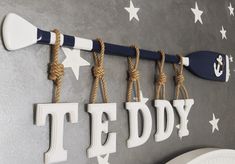 there is a sign that says teddy hanging on the wall with some hooks and rope