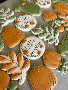 some decorated cookies on a table with writing on them and leaves in the middle one cookie has been cut out to look like pumpkins