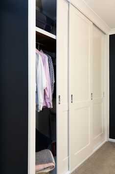 an open closet with clothes hanging on hangers