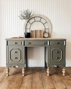 an antique desk with books and vase on top