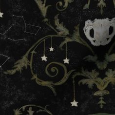 a black and gold wallpaper with white stars, swirls and scrolls on it