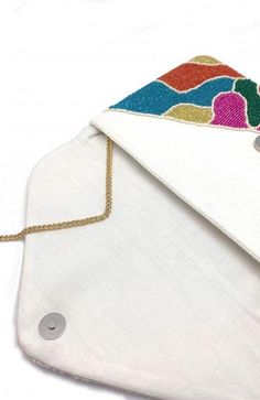 The Puzzle Piece Beaded Clutch features a metallic orange, green, fuchsia, blue and chartreuse beaded print design and can be carried as a handheld or worn as a cross-body and shoulder bag using the detachable chain strap. Material: 100% Cotton (Interior) Size: 6.75” x 10.5”Strap: 46" Cheap Multicolor Rectangular Clutch, Multicolor Crossbody Clutch For Party, Blue And Chartreuse, Metallic Orange, Sequin Clutch, Beaded Handbag, Rainbow Beads, Beaded Clutch, Puzzle Piece