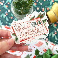 a hand holding a sticker with the words special delivery written in red and white