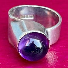 "Here's a modernist amethyst ring that was handcrafted in the studio of the Finnish Australian gold and silversmith Tor Schwanck.  Born in 1935 into a metalworking family, Tor could trace this heritage back to a 15th-century armourer. He was four when the Soviets bombed Helsinki and became one of thousands of children evacuated to foster families in Sweden. He completed his five-year bench apprenticeship in Malmö, studying design and fine art at night. In 1961 he arrived in Melbourne with \"noth Studying Design, Tor Design, Australian Gold, Study Design, St Kilda, Rainbow Moonstone Ring, Cabochon Ring, Sterling Silver Cuff, 15th Century