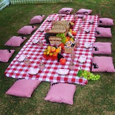 a picnic table set up with red and white checkered cloths