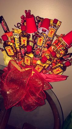 a basket filled with candy and candies on top of a glass table next to a wall