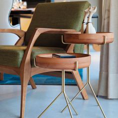 a wooden chair with a book on it next to a table