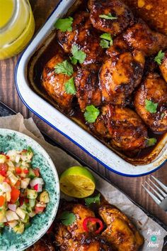 two plates of chicken with salsa and a glass of orange juice