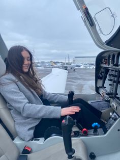 a woman sitting in the cockpit of an airplane