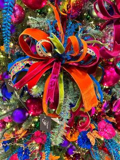 a colorful christmas tree decorated with ribbons and ornaments for the holiday season, in bright colors