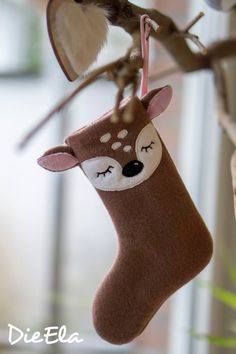 a christmas stocking hanging from a tree with a deer on it's face