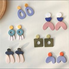 several pairs of earrings are displayed on a white surface